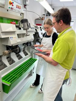 Ausbilder und Auszubildende bei der Arbeit an einer Fräsmaschine in der Orthopädie-Werkstatt