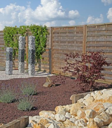 Gestalteter Garten mit Gabionensäulen und Kiesbeeten